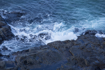Fototapeta na wymiar Waves Washing Over Rocks at Beach
