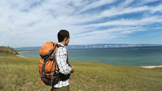 Smiling Hiker young Man relaxing with serene view of lake Baikal. landscape Travel Lifestyle hiking concept summer vacations outdoor