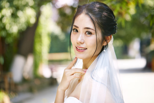 outdoor portrait of happy asian bride