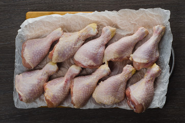 Fresh raw chicken legs arrangement on kitchen cutting board