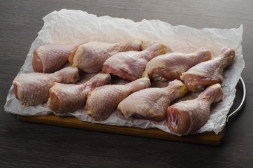 Fresh raw chicken legs arrangement on kitchen cutting board