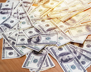 The Us Dollars put on wooden desk in blurry light design background,vintage tone ,