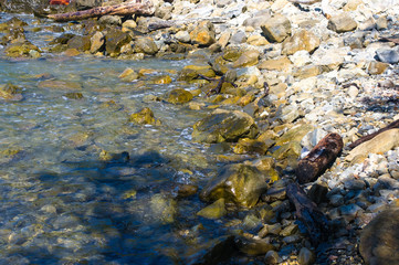 rocky sea shore with pebble beach, waves with foam