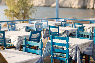 Tables and chairs in a street restaurant in Kamari on Santorini