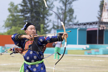 Young man shoots from a sports bow