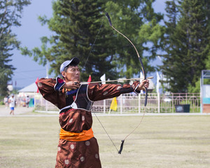 Young man shoots from a sports bow