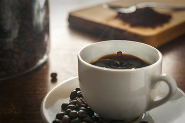 Drop falling into a steaming cup of coffee