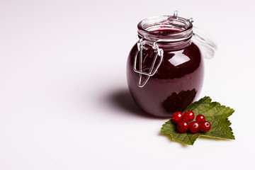 fresh red currants and jam on a white background
