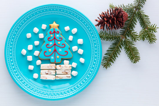 Homemade Christmas tree cookie, marshmallow and nougat on a plate.