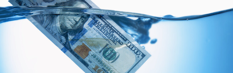 Money concept showing US Dollar sinking in water as a symbol of global economic crisis