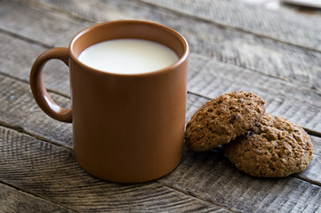 a glass of milk with a biscuit