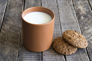 a glass of milk with a biscuit