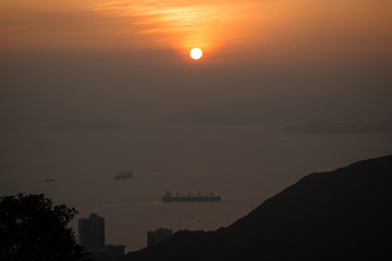 Fototapeta premium Ocean, ships, coastline and sunset in Hong Kong, China, viewed from the Victoria Peak.