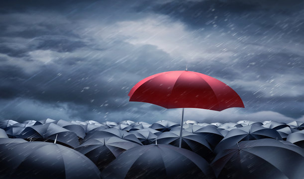 Roter Regenschirm &uuml;ber schwarzen Regenschirmen