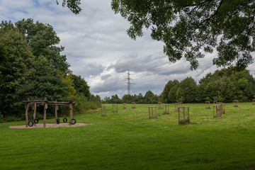 Playground on a meadow with power lines in the background