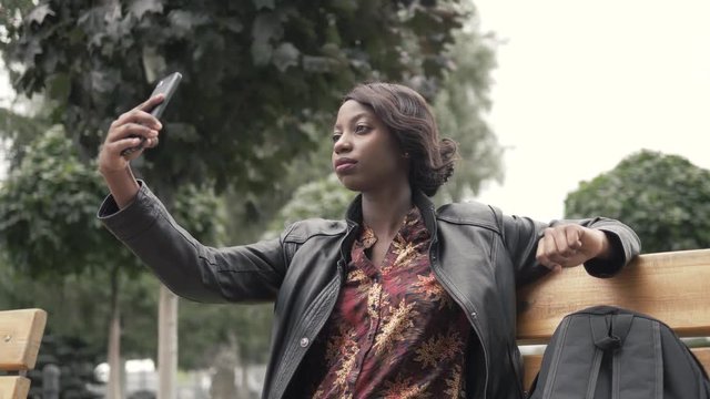 Portrait of stylish young african woman taking selfie with her smart phone