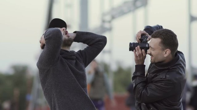 Two men have fun at the bridge with camera