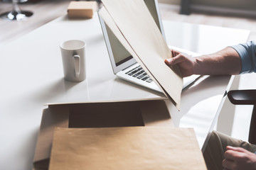 Young guy is working at table with his mail