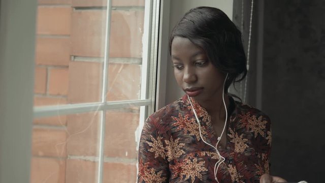 Young black woman listening music travelling looking outdoor the window, pensive - thoughtful, thinking future, music concept, african american student think about home