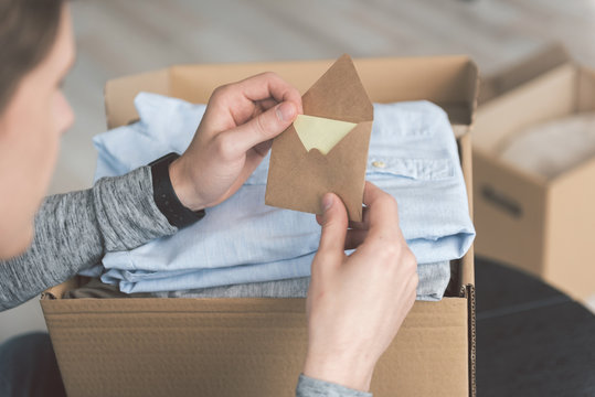 Man hands holding envelope in room