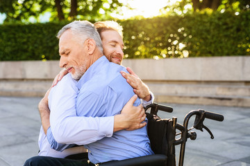 To the old man who sits in the park on a wheelchair came his son. He is hugging the old man