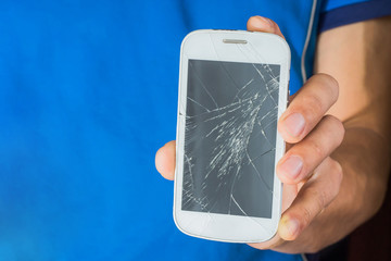 man holds cracked smartphone . Screen broken phone in hand