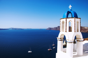 Fototapeta na wymiar Santorini Island, the city of Oia, Greece. Traditional Greek architecture, white houses and churches with blue domes above Caldera, Aegean Sea.