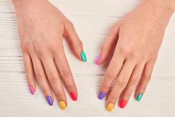 Obraz na płótnie Canvas Female hands with multicolored varnish on nails. Girl hands with nails polished with different colors. Summer fashion manicure.