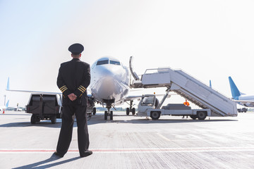 Aviator glancing at big aircraft