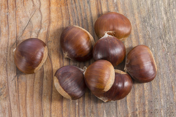 Fresh chestnuts isolated on old wooden background