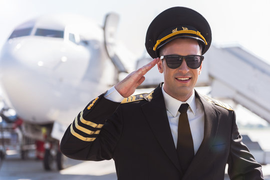 Cheerful smiling aviator standing outside