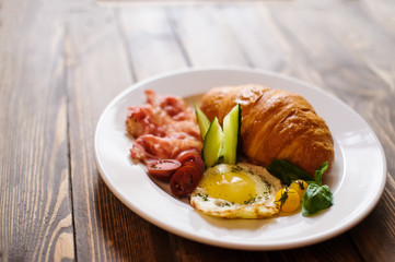 Fresh croissant with ham and salad