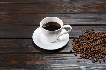 Coffee mug and coffee beans on a brown vintage table.