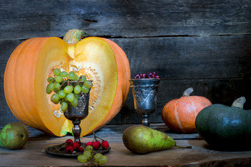 The frame of the gifts of autumn pumpkins, corn, fall leaves, tomatoes, red berry cranberry and...