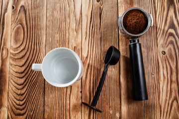 Ground coffee and moka pot coffee maker over rustic wooden background