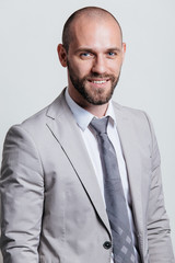 Portrait of a successful businessman in a suit, business coach / consulting. Studio shot with a flipchart on a white background.
