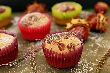 Colorful homemade cupcakes made of cornflour with hint of chocolate with chestnut in the background
