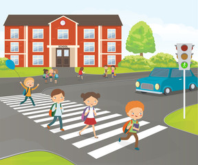 Fototapeta na wymiar School children cross road on pedestrian crossing, near school building