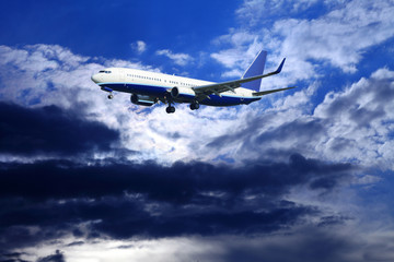 Odrzutowy samolot pasażerski na tle pochmurnego nieba. - obrazy, fototapety, plakaty