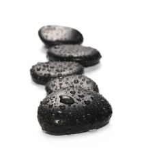 Fototapeta na wymiar Black spa stones with water drops isolated on white background