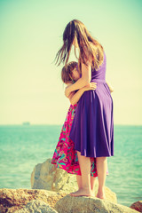 Mother and daughter posing at sea rocks