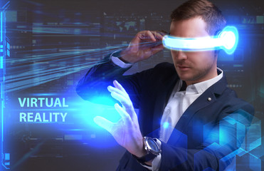 Business, Technology, Internet and network concept. Young businessman working in virtual reality glasses sees the inscription: Virtual reality