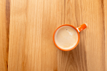 Cup of coffee on wooden table, top view