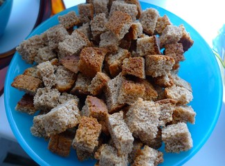Appetizing croutons from rye bread in a blue plate, macro