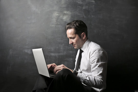 Concentrated businessman using a laptop