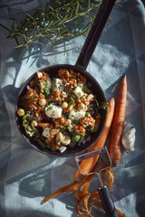 Bulgurgericht auf Tuch mit Zutaten geschälter Karotte und Rosmarin