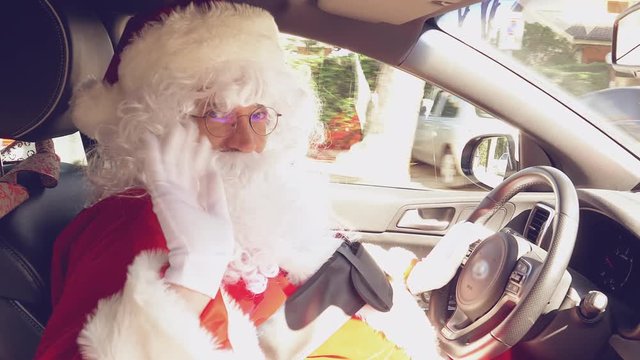 Very happy Santa Claus saying hello ok sign while driving car 4K closeup
