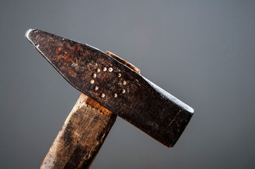 Old vintage hammer with wooden handle on gray background, horizontal image