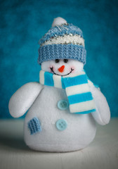 Snowman toy on blue background.