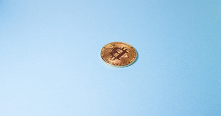 Cryptocurrency physical golden bitcoin coin. Bitcoin, golden bitcoin, yellow bitcoin in blue paper background